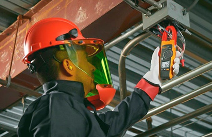 Técnico mantenimiento realizando un análisis energético usando pinzas amperimetricas
