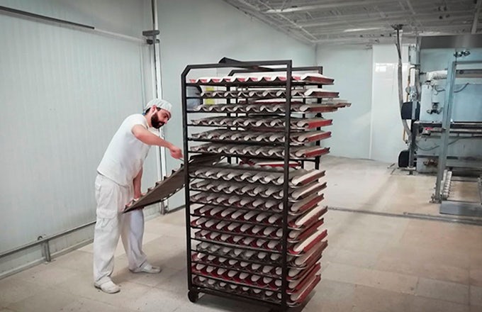 Panificadora industrial con un trabajador poniendo panes