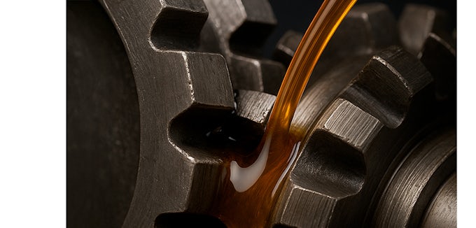 Primer plano de engranajes metálicos con aceite industrial fluyendo entre los dientes, ilustrando la lubricación en condiciones de alta fricción.