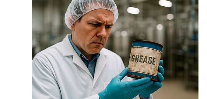 Auditor con bata blanca y guantes revisando un bote de grasa industrial antiguo en mal estado en una fábrica alimentaria