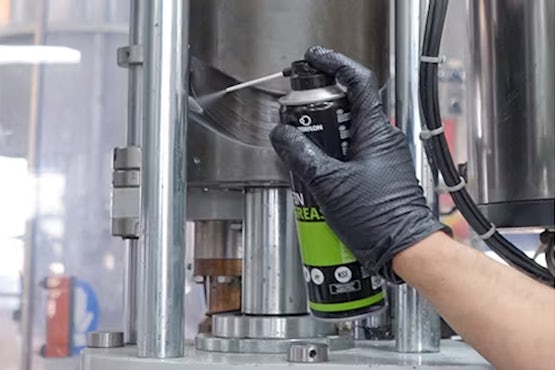Aplicación de grasa alimentaria Interflon Fin Grease en maquinaria de embotellado.