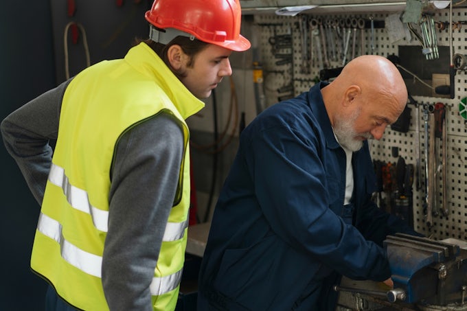 Técnico de mantenimiento industrial enseñando a un nuevo técnico de mantenimiento