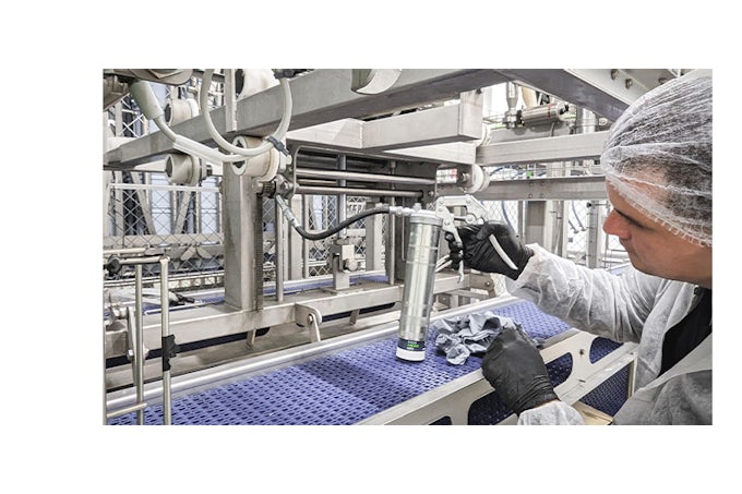 Técnico de mantenimiento Interflon lubricando una maquina con la pistola de engrase y el G-Coupler