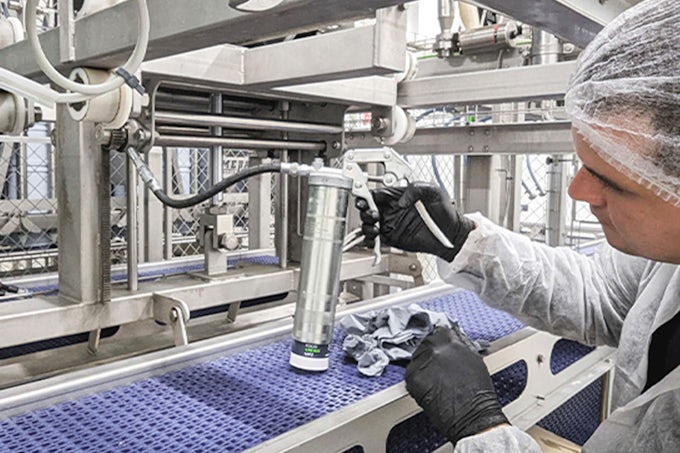 Técnico de mantenimiento Interflon lubricando una maquina con la pistola de engrase y el G-Coupler