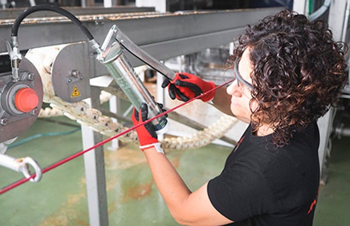 Técnica de mantenimiento lubricando tetillas de engrase durante las paradas de producción en verano