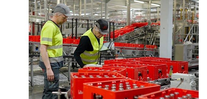 Técnicos supervisando línea de embotellado en planta de Coca-Cola con mantenimiento optimizado por Interflonion coca cola interflon