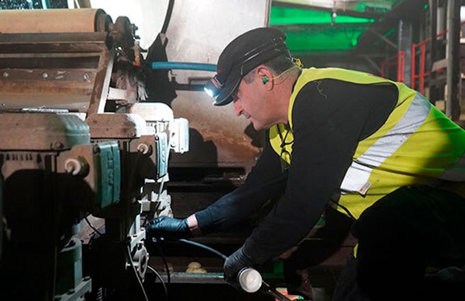Técnico de Interflon aplicando lubricante a una máquina con la pistola de engrase