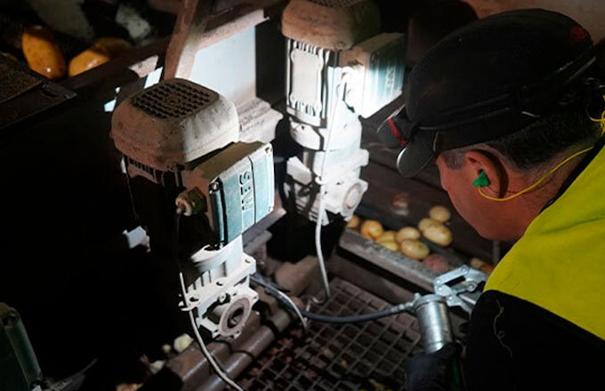 Técnico de Interflon lubricando con una pistola de engrase a una máquina.
